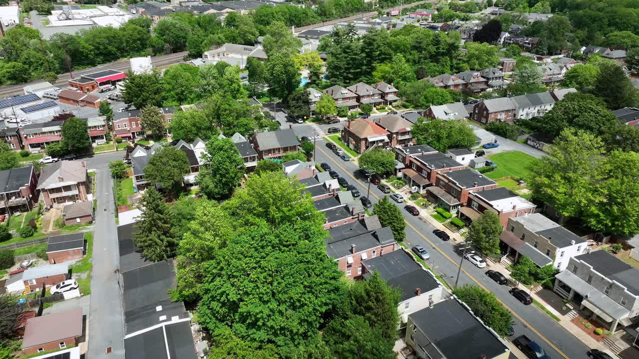 Townhouse in American neighborhood. Aerial flyover shot. Historic American two story homes. Wide shot. Green trees in district.