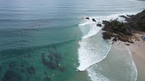 surfistas en la bahía de byron en el paso en nueva gales del sur, australia