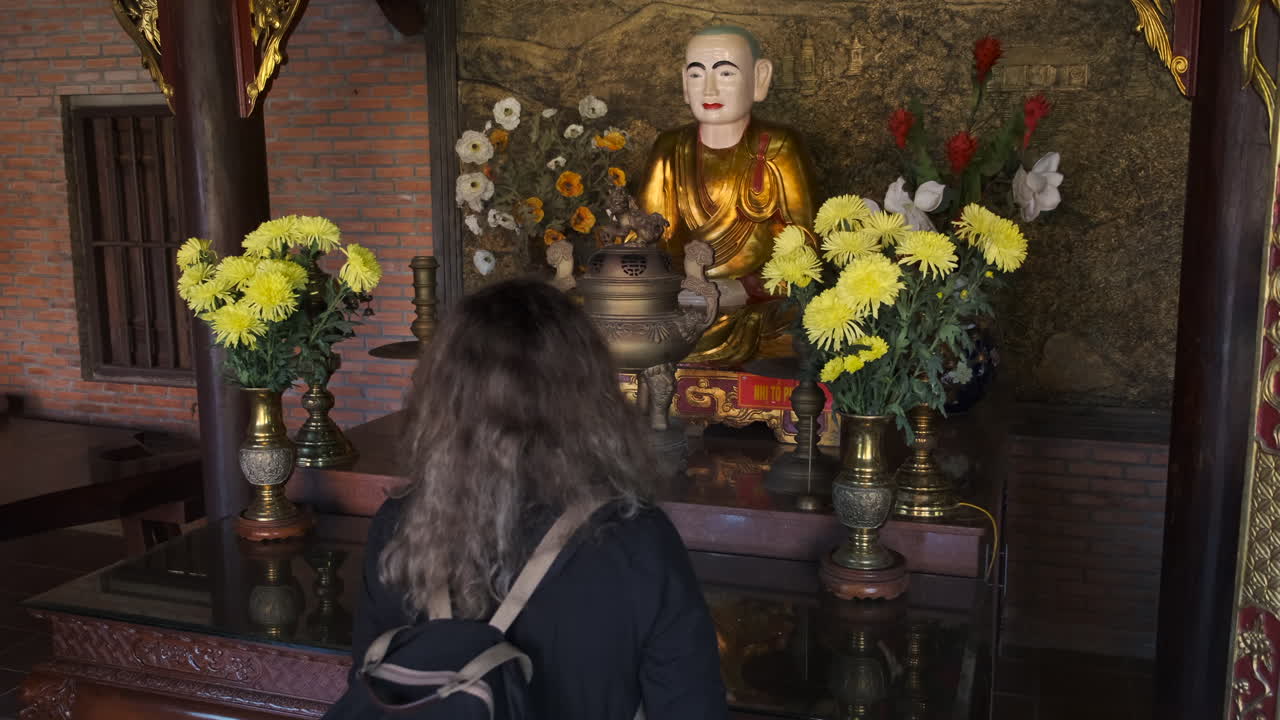Woman Praying at a Buddhist Temple in Vietnam