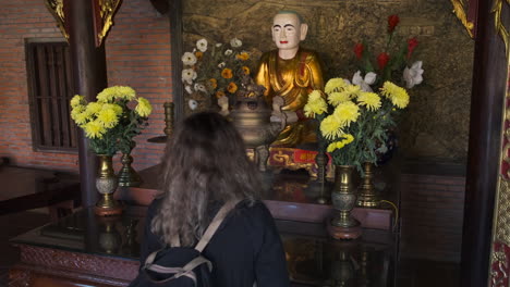 woman praying at a buddhist temple in vietnam