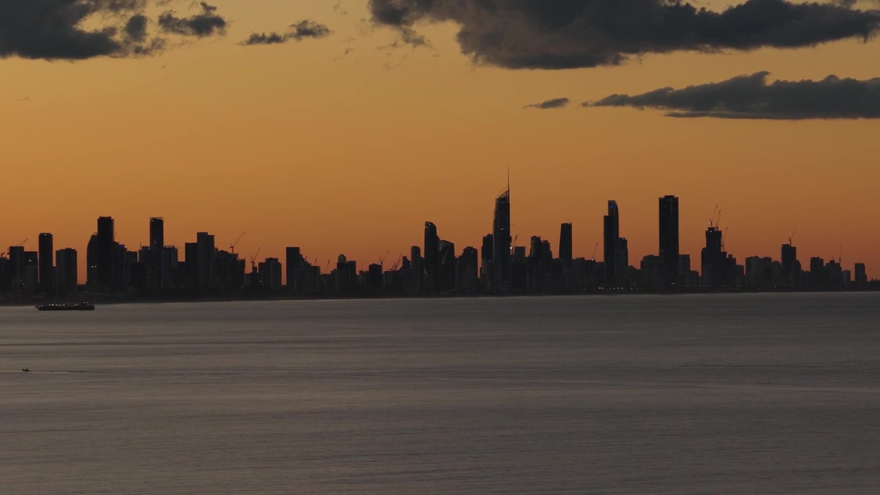 Silueta del horizonte de Surfers Paradise vista desde el océano durante el atardecer en Queensland, Australia. - toma aérea.