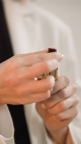 elegant woman opens red lipstick turning tube to paint lips. stylish lady uses cosmetic product for professional makeup on anniversary closeup