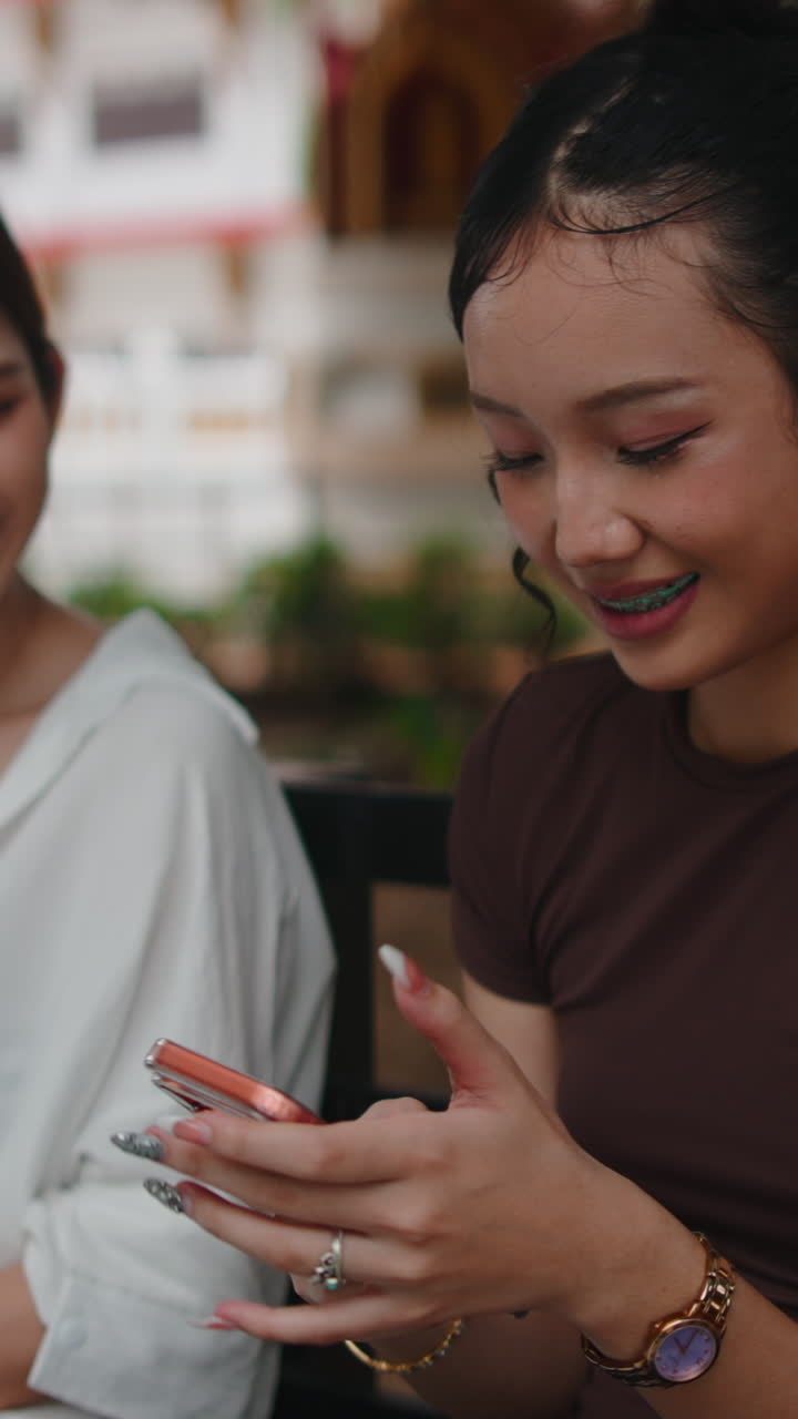 Two Asian Women Friends Socializing Outdoors with Smartphone
