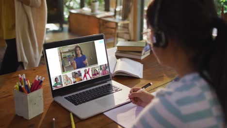 Composite-of-girl-using-laptop-for-online-lesson-at-home,-with-diverse-teacher-and-class-on-screen