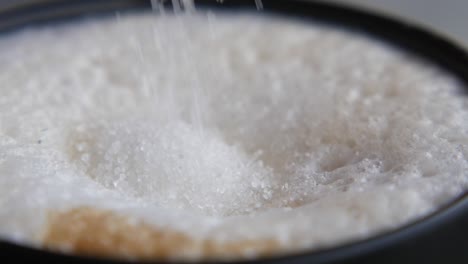 adding sugar to a cappuccino