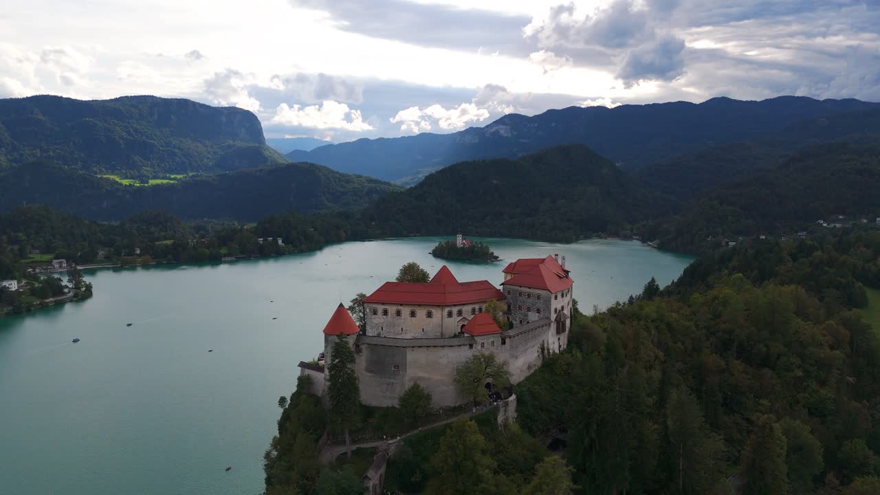 Il castello di Bled sopra il lago di Bled, Slovenia, fluide riprese aeree, splendida vista sull'acqua turchese, le montagne e la natura