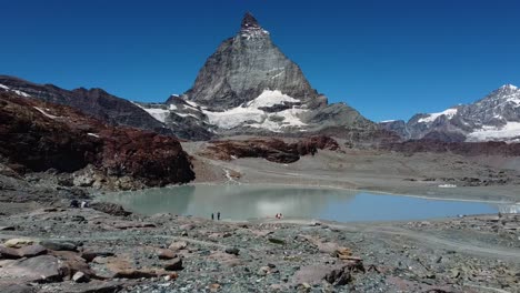 Majestic-mountain-peak-with-glacier-lake-bellow-in-Switzerland,-dolly-forward-view