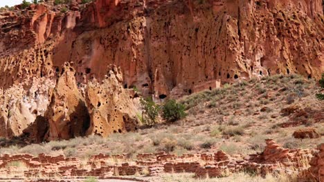 Pan-up-shot-of-a-ancient-mountain-wall,-at-Bandelier-National-Monument,-on-a-cloudy-day,-in-Santa-Fe,-New-Mexico,-USA