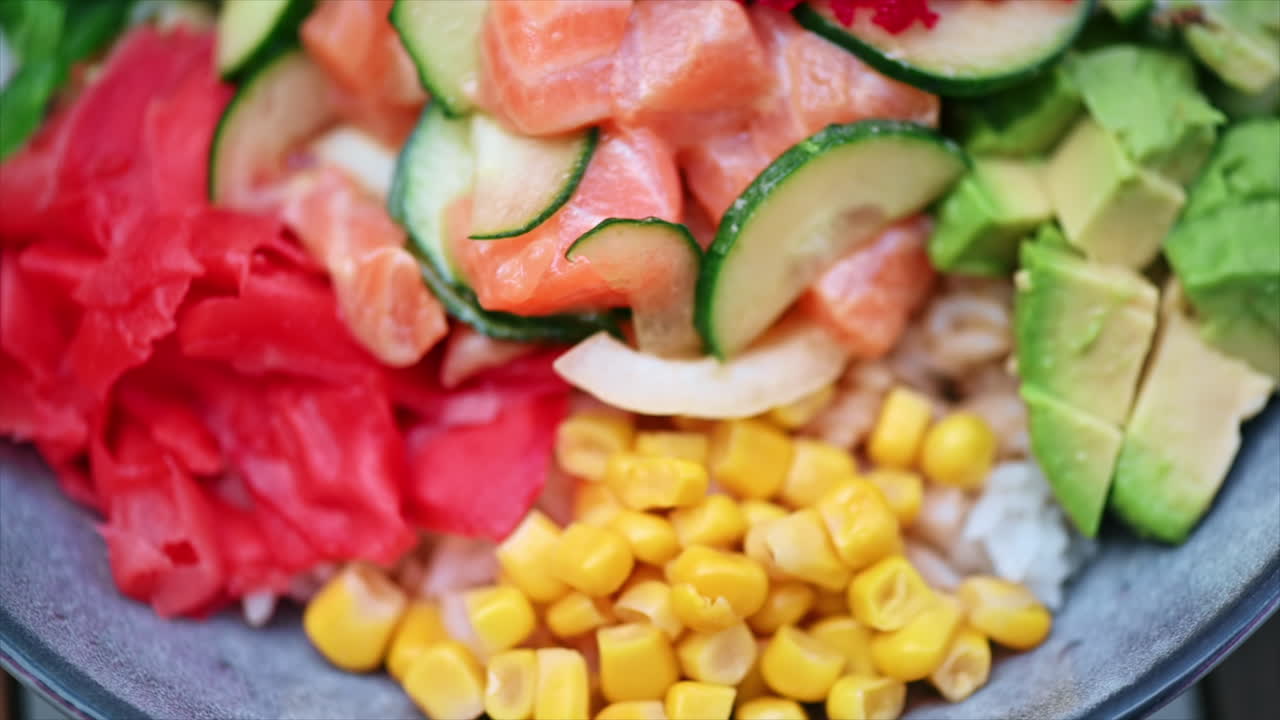 Close view of poke with vegetables, seeds and seafood in a bowl