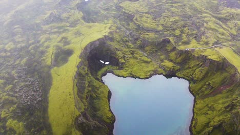 vista pintoresca de tjarnargigur, cráter de estanque con reflejos del exuberante musgo verde en lakagigar, islandia