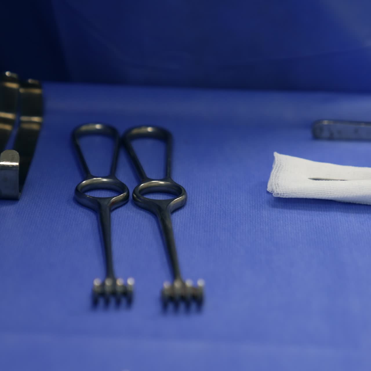 Metal instruments prepared for operational procedure. Tools lying on the special table laid with blue cloth. Close up