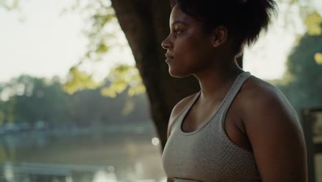 focus young african-american woman dynamically walking across the park in summer day.