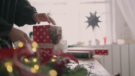 Young-beautiful-woman-gift-wrapper-wraps-up-a-Christmas-gift-and-decorates-with-decorative-eco-friendly-decorations-in-slow-motion