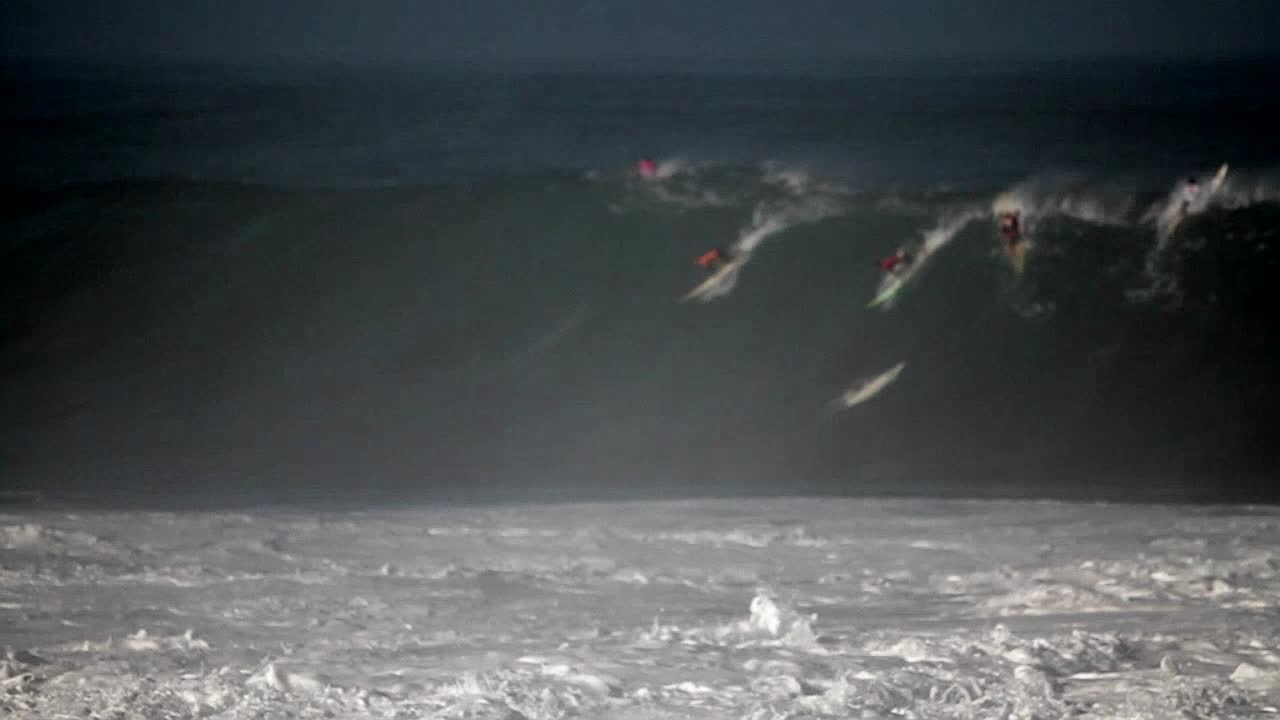 múltiples surfistas montan olas muy grandes en hawaii 3