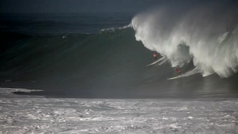 múltiples surfistas montan olas muy grandes en hawaii 3