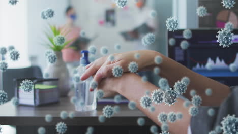 covid-19 cells floating against mid section of woman sanitizing her hands at office