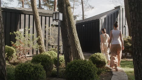 two women walking in a modern garden