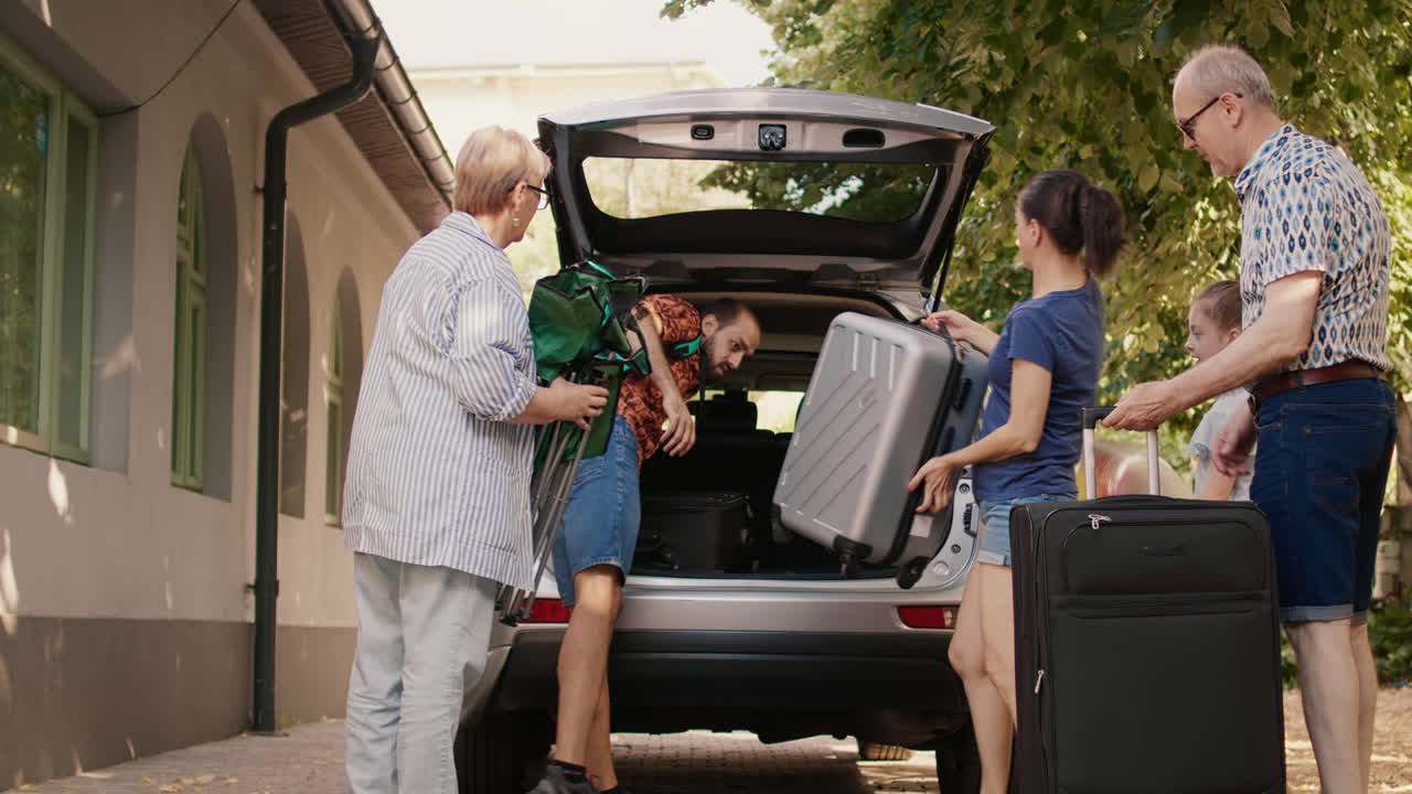 Family packs luggage into car for a summer vacation