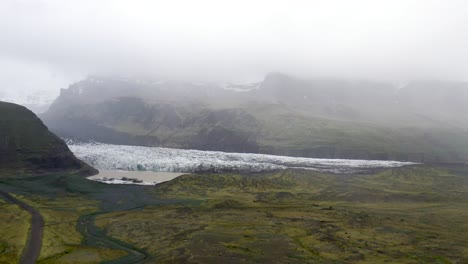 iceland glacier wide shot with water and green grass with drone video moving forward