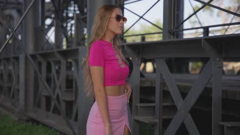 woman striking a pose next to a railway line, radiating beauty and confidence