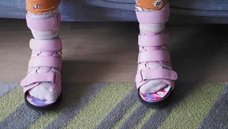 close-up of child's feet in pink orthopedic braces