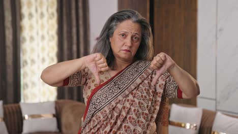 vieja mujer india decepcionada mostrando los pulgares hacia abajo