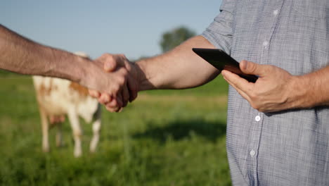 two farmers shake hands in close-up