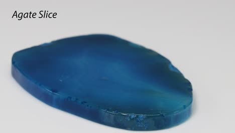 una rebanada de ágata azul pulida gira en la exhibición.