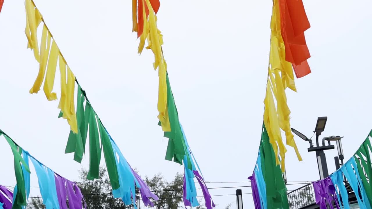 Brightly colored streamers sway in the breeze, creating a vibrant display against a clear sky.