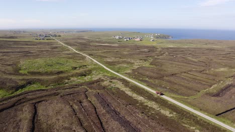 Kippbare-Drohnenaufnahme-Eines-Torfstechers,-Der-Seinen-Traktor-Voller-Torf-Nach-Hause-In-Der-Nähe-Seines-Torfmoors-Fährt