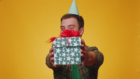 smiling man presenting birthday gift box stretches out hands, offer wrapped present career bonus