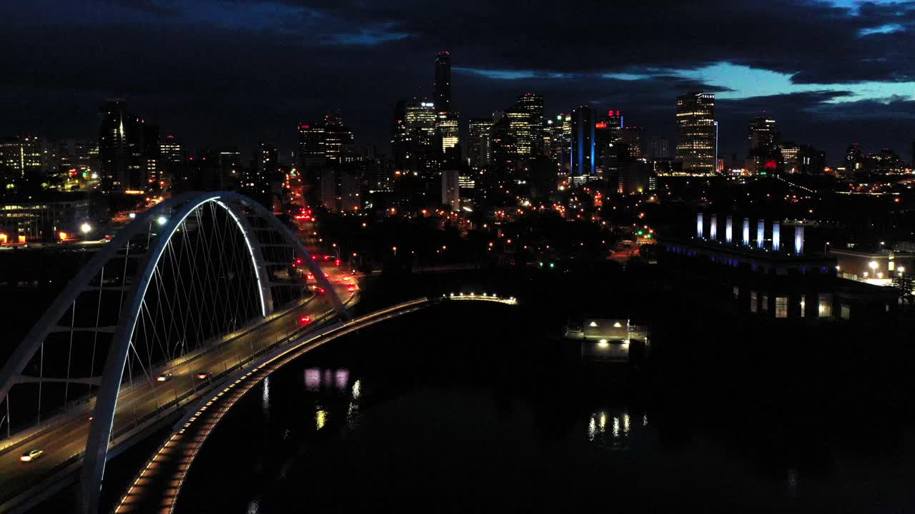 Aerial drone view of the Edmonton Walterdale Bridge over the North Saskatchewan River during a summer night and the downtown skyline in the background