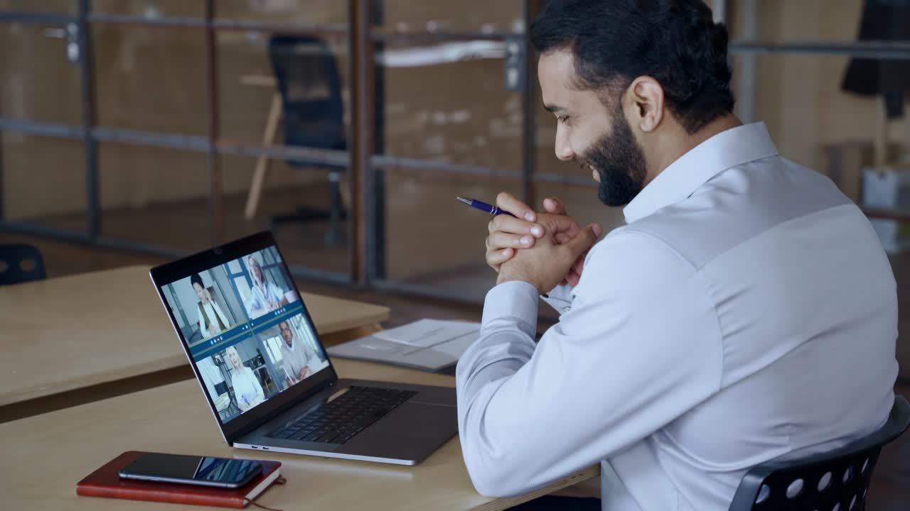 Indian manager leading videoconference with team business people on computer.