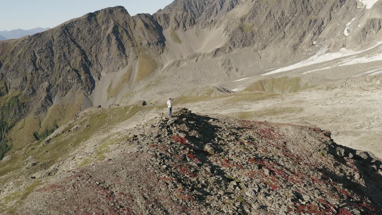 paisaje aéreo de las montañas kenai del campo de hielo duro en el parque nacional de alaska, ee.uu., trekker parado solo en la cima de la formación rocosa de la cresta en el desierto