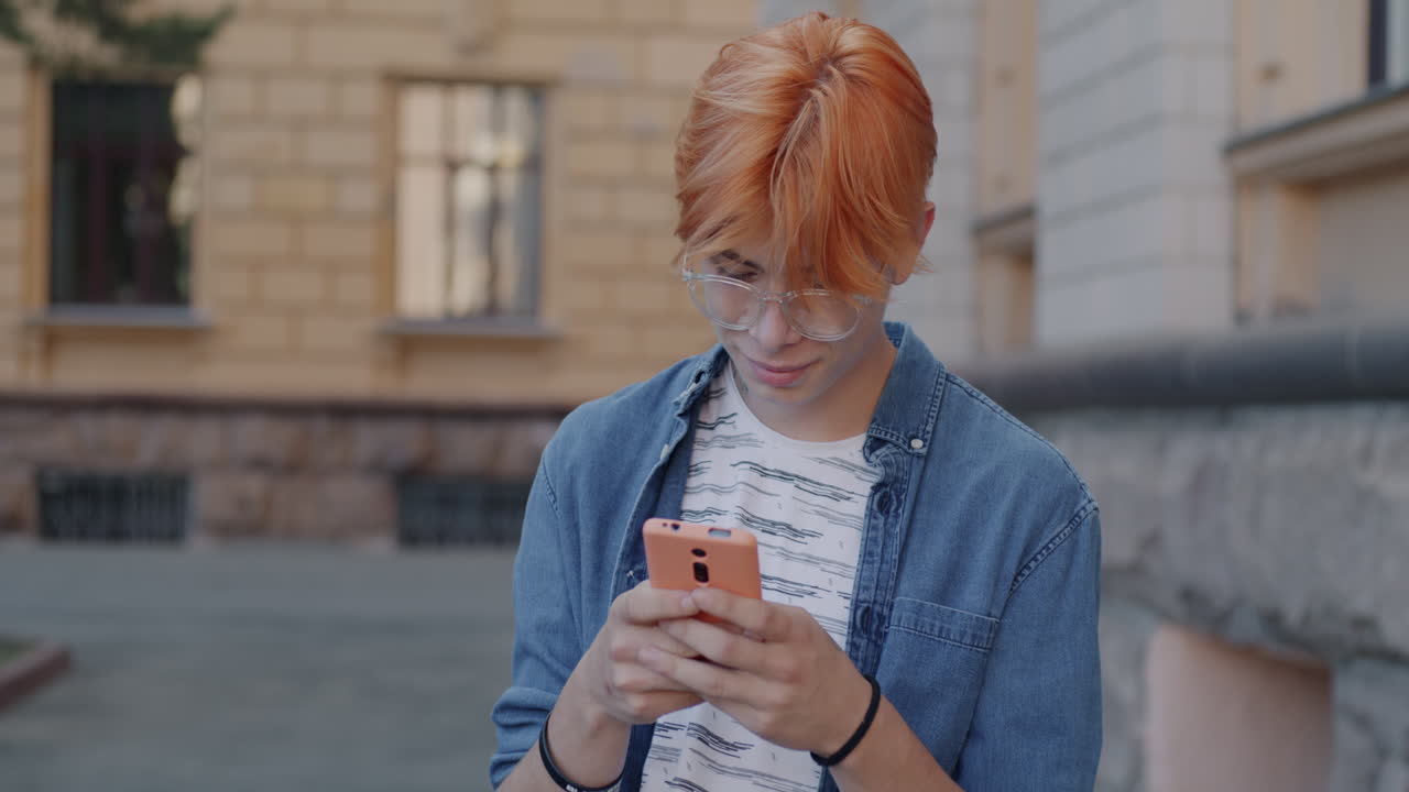 Adolescente che usa un cellulare in città