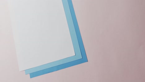 Close-up-of-blank-and-blue-cards-on-white-background-with-copy-space-in-slow-motion