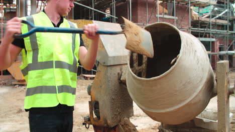 trabajador de la construcción en el sitio de construcción mezclando cemento