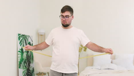 boy measuring his waist in the bedroom