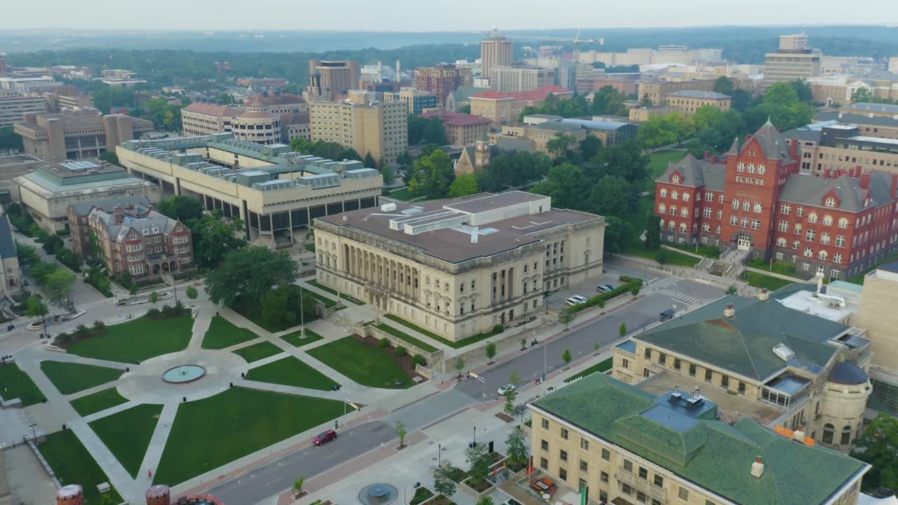 Aerial, historical building and green square in city, soft light, rotating shot