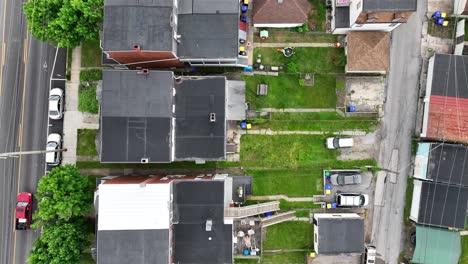 Toma-Aérea-A-Vista-De-Pájaro-De-Una-Zona-Residencial-Con-Casas-Y-Botes-De-Basura-En-EE.UU.