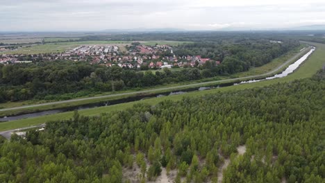 pueblo pequeño al lado de un canal fluvial controlado y un bosque de lagos