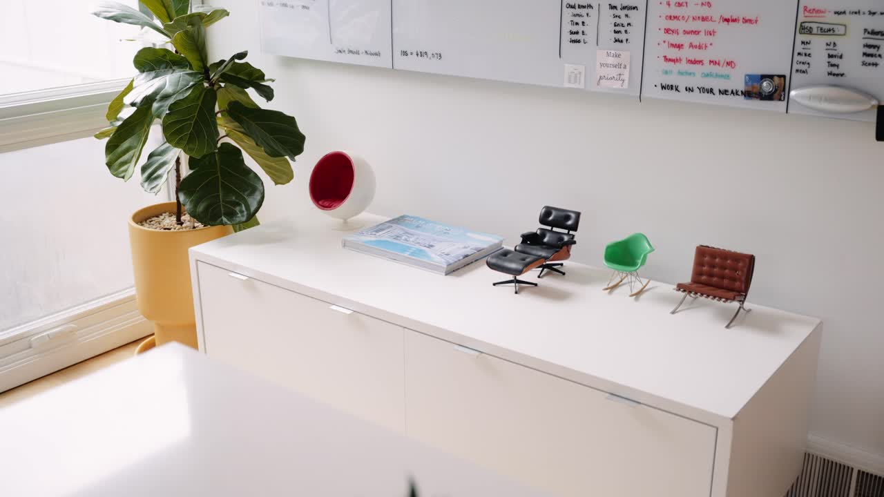 a small dresser in a home office decorated with miniature versions of luxury office chairs