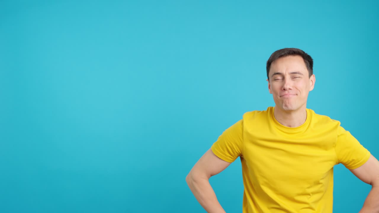 Man in yellow shirt pointing on blue background
