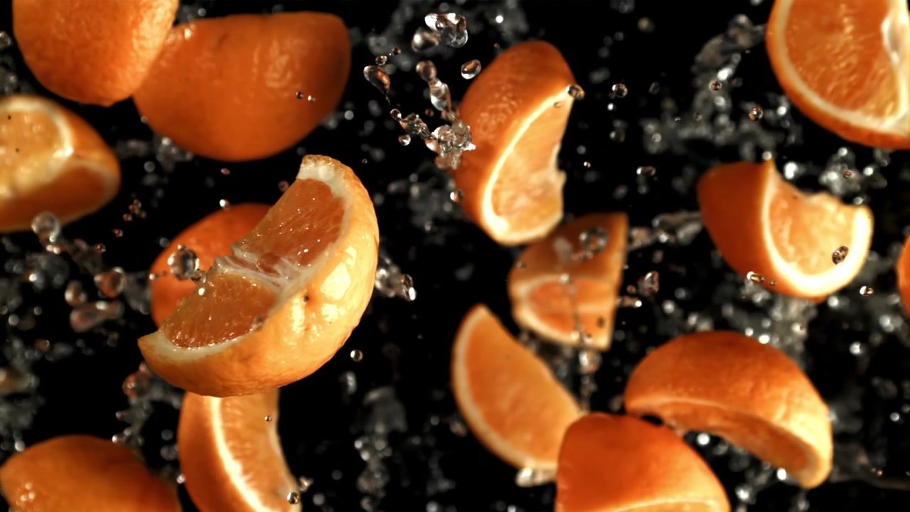 Super rallentatore di arance fresche e acqua che schizza su sfondo nero