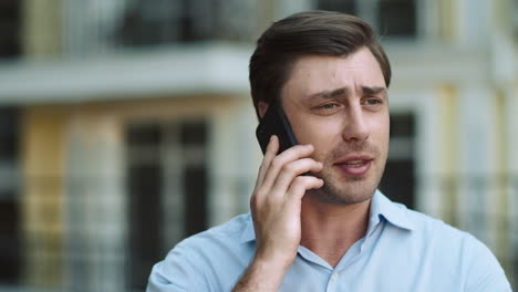 portrait successful business man walking with cell phone outside