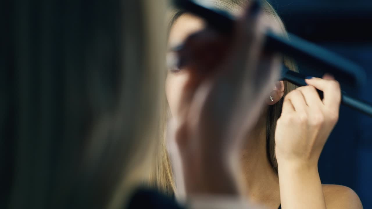 mujer atractiva corrige el maquillaje frente al espejo 1