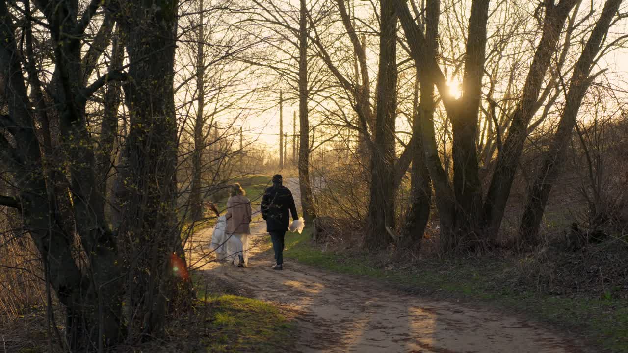 Paar spaziert in der Natur während der goldenen Stunde an ihrem Hochzeitstag, sanfte und warme Stimmung