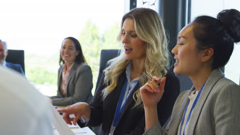 multi-cultural business team meeting and collaborating around table in modern office building