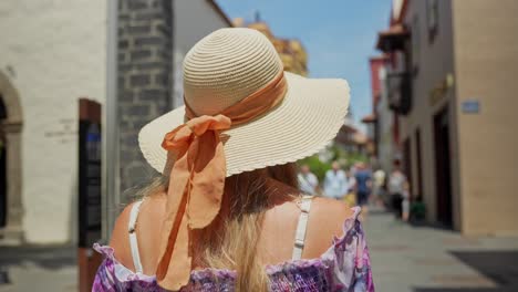 belle femme portant un chapeau de paille en marchant dans la ville de puerto de la cruz