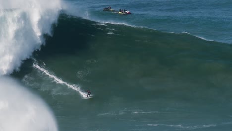 slow motion of a big wave surfer caio from brazil riding a monster wave in nazaré, portugal